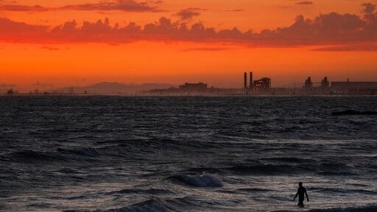 A man wades into the ocean at sunset,(AP file for representation)