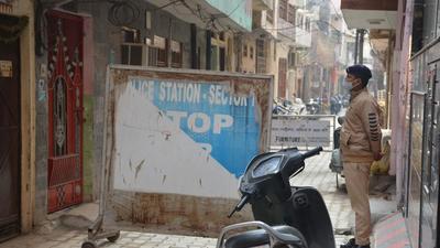 A cop guarding the sealed area around the residence of a 20-year-old man, who was found infected with the Omicron variant, in Manimajra, Chandigarh, on Tuesday. (Sant Arora/HT) A cop guarding the sealed area around the residence of a 20-year-old man, who was found infected with the Omicron variant, in Manimajra, Chandigarh, on Tuesday. (Sant Arora/HT)