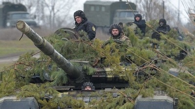 Service members of the Ukrainian armed forces drive tanks towards a pontoon bridge before crossing the Aidar River during military drills near Novoaidar in the Luhansk region, Ukraine.&nbsp; (REUTERS)