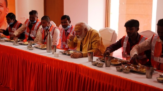 PM Modi indulges in a traditional meal with workers during the inauguration of Kashi Vishwanath Dham Corridor.(AP)