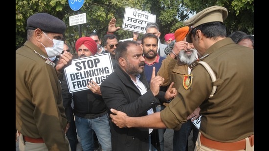 Police officials trying to pacify PU teachers protesting over non-implementation of UGC pay scales at Matka Chowk in Chandigarh on Tuesday. (Ravi Kumar/Hindustan Times)