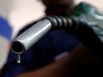 A worker holds a fuel nozzle at a petrol pump in Mumbai&nbsp;