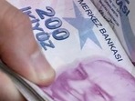 A merchant counts Turkish lira banknotes at the Grand Bazaar in Istanbul, Turkey.