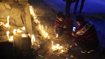 A Naga man takes a photograph of another lighting a candle in memory of fourteen civilians killed by Indian army soldiers earlier this month in Nagaland. The killings prompted calls for the revocation of the Armed Forces Special Powers Act, or AFSPA, that gives security forces sweeping powers to search, seize and even shoot suspects (AP)