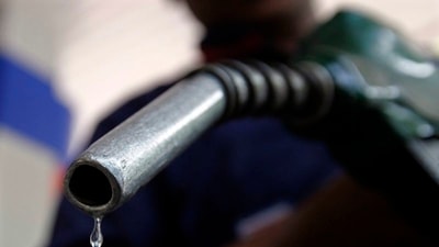 A worker holds a fuel nozzle at a petrol pump in Mumbai&nbsp; (REUTERS)