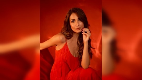 In her recent stills, the stunning Malaika Arora posed in a bright red long strappy fringe dress.(Instagram/@manekaharisinghani)