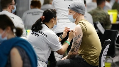 People receive a booster dose in a Covid-19 pop-up vaccination centre at Chelsea football ground, Stamford Bridge, in London. (Reuters)