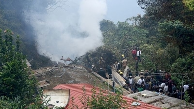 People stand near the debris of the Russian-made Mi-17V5 helicopter in Tamil Nadu. (Reuters)