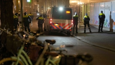 Police officers line-up to monitor protestors during a small anti-Covid-19 restriction demonstration in the Hague, the Netherlands, Saturday, Dec. 18, 2021. (AP) Police officers line-up to monitor protestors during a small anti-Covid-19 restriction demonstration in the Hague, the Netherlands, Saturday, Dec. 18, 2021. (AP)
