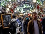 Shoppers, some wearing face coverings to combat the spread of Covid-19, walk past stalls and shops in the Apple Market in Covent Garden on the last Saturday for shopping before Christmas, in central London on December 18, 2021. (AFP)