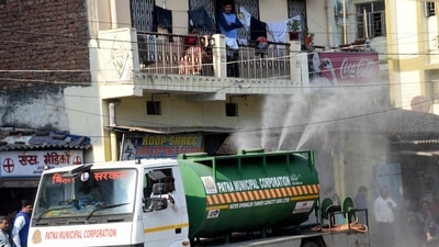 Patna Municipal Corporation workers spray disinfectant in a residential area amid Omicron threat. (PTI)