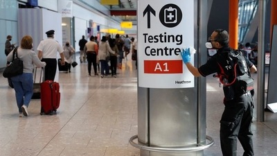 A worker sanitises a sign at the International arrivals area of Terminal 5 in London's Heathrow Airport, Britain. (Reuters / File)
