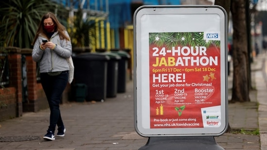 A pedestrian walks past a sign for a 24-hour vaccination centre in north east London.&nbsp;(AFP)
