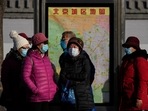 Commuters wearing face masks to protect against the coronavirus wait for their buses at a bus stand in Beijing on Sunday. Commuters wearing face masks to protect against the coronavirus wait for their buses at a bus stand in Beijing on Sunday.