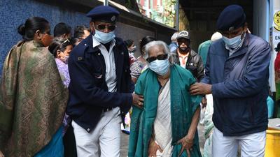 Police personnel help an elderly woman during Kolkata Municipal Corporation Election at Tran Bhavan School in Kolkata on December 19. (Samir Jana/HT Photo) Police personnel help an elderly woman during Kolkata Municipal Corporation Election at Tran Bhavan School in Kolkata on December 19. (Samir Jana/HT Photo)