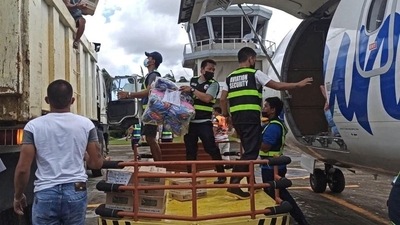 Aviation personnel assist in unloading packs of relief goods for victims of typhoon Rai, in Surigao del Norte province, Philippines. (REUTERS)