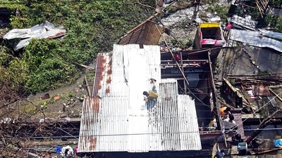 A man fixes the roof of his damaged house after Typhoon Rai ripped roofs, toppled trees and knocked out power in southern and central island provinces. (AP) A man fixes the roof of his damaged house after Typhoon Rai ripped roofs, toppled trees and knocked out power in southern and central island provinces. (AP)