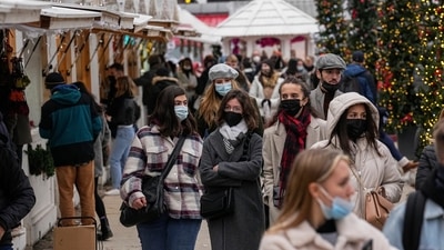 Shoppers wearing face masks to protect against Covid-19 walk along the Christmas market at Tuilerie garden in Paris. (AP) Shoppers wearing face masks to protect against Covid-19 walk along the Christmas market at Tuilerie garden in Paris. (AP)
