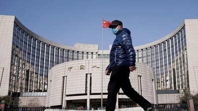 A man wearing a mask walks past the headquarters of the People's Bank of China, the central bank, in Beijing, China. (Reuters) A man wearing a mask walks past the headquarters of the People's Bank of China, the central bank, in Beijing, China. (Reuters)