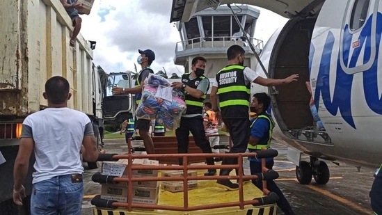 Aviation personnel assist in unloading packs of relief goods for victims of typhoon Rai, in Surigao del Norte province, Philippines.(REUTERS)