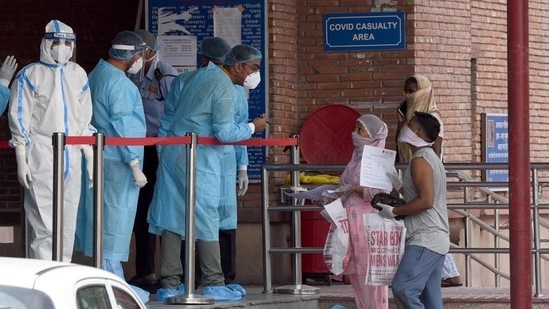 Medical professionals interact with visitors at the Covid-19 ward in Lok Nayak Jai Prakash Narayan Hospital (LNJP). (Sonu Mehta / HT Photo/ File)