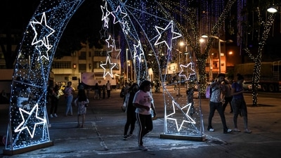 People walks by Christmas ornaments illuminated as part of the Christmas festivities. (AFP) People walks by Christmas ornaments illuminated as part of the Christmas festivities. (AFP)