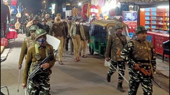 Police, along with CRPF personnel, carrying out a flag march in Hallomajra after campaigning concluded in Chandigarh on Tuesday. (HT Photo)