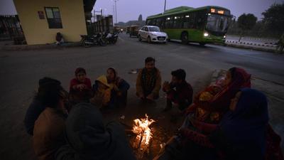People huddle around a bonfire at Sarai Kalen Khan, on Wednesday evening. (Sanjeev Verma/HT PHOTO) People huddle around a bonfire at Sarai Kalen Khan, on Wednesday evening. (Sanjeev Verma/HT PHOTO)