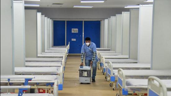 A worker carries an oxygen concentrator inside the Covid-19 facility of Commonwealth Games Village in view of the rising Omicron cases in New Delhi on Wednesday. (PTI)