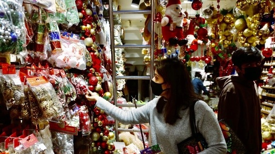 A woman purchases decorative items ahead of the Christmas festival at Khan Market, in New Delhi on December 22, 2021.&nbsp;(ANI photo)