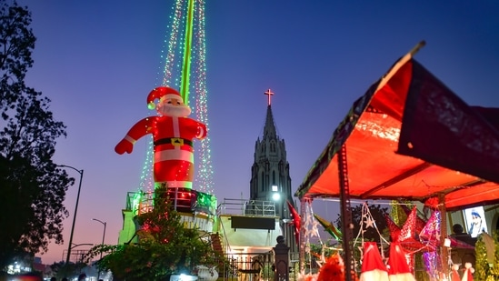 A Santa Clause's statue is being installed at the entrance of St Basilica Church ahead of the Christmas festival, at Shivaji Nagar in Bengaluru, Monday, Dec. 20, 2021. (PTI Photo/Shailendra Bhojak)