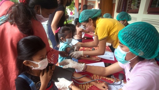 Students check their health before receive the Sinovac Covid-19 vaccine during a vaccination campaign at an elementary school in Bali, Indonesia&nbsp;(AP Photo/Firdia Lisnawati)