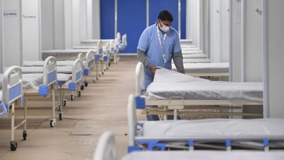 A worker prepares a bed for Covid patients in Commonwealth Games Village in view of the Omicron cases, in New Delhi. (PTI)