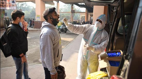 A health worker collects a swab sample for a Covid test in Delhi. (Sanchit Khanna/HT Photo)