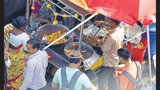 Stall staff places vada pav in a newspaper at Swargate chowk , on Friday. (Rahul Raut/HT PHOTO)