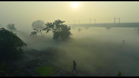 Commuters on a cold morning near Mayur Vihar when the Delhi pollution gauges touched 415. (Raj K Raj/HT Photo)