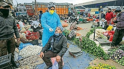 A health worker collects the swab sample of a vendor in Jammu. (PTI ) A health worker collects the swab sample of a vendor in Jammu. (PTI )