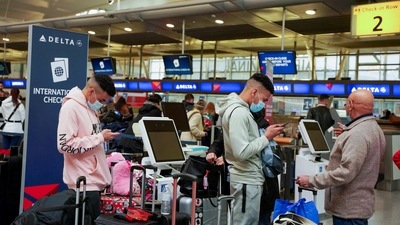 Passengers line up at John F Kennedy international airport in the US after airlines announced numerous flights were cancelled due to spread of the Omicron coronavirus variant. (Reuters Photo)