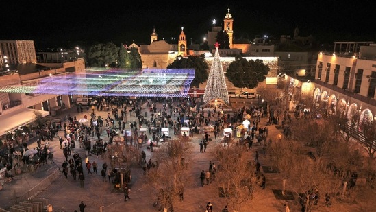 This year, the celebrations were more vibrant -- but still a fraction of their usual size. In picture - Visitors walk in Manger Square on Christmas eve outside the Church of the Nativity, revered as the site of Jesus Christ's birth, in the biblical city of Bethlehem.(AFP) This year, the celebrations were more vibrant -- but still a fraction of their usual size. In picture - Visitors walk in Manger Square on Christmas eve outside the Church of the Nativity, revered as the site of Jesus Christ's birth, in the biblical city of Bethlehem.(AFP)
