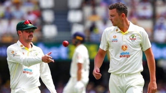 Australia's Travis Head (left) passes the ball to teammate Josh Hazlewood during day 3 of the first Ashes cricket Test.(AP)