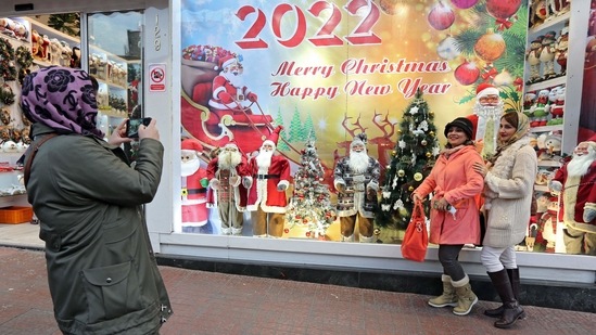 Iranians pose for a picture in front of a shop selling Christmas decorations in the capital Tehran (Photo by AFP)