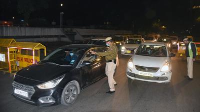 Delhi police personnel check vehicles during night curfew, at Connaught Place in New Delhi on Monday. (ANI) Delhi police personnel check vehicles during night curfew, at Connaught Place in New Delhi on Monday. (ANI)