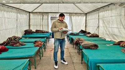 Each bed here is furnished with a mattress, a green sheet and a blanket.