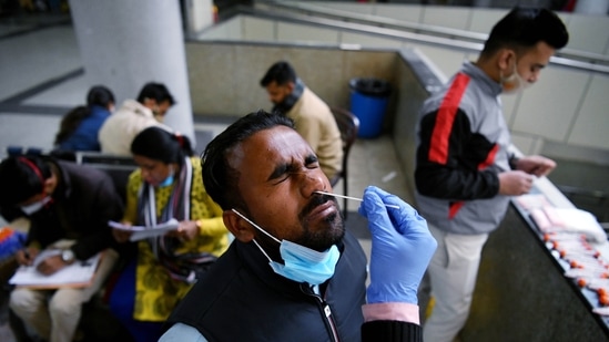 A healthcare worker takes a nasal swab sample of a passenger for the Covid-19 test, at Kashmere Gate ISBT, in view of rising Omicron cases, in New Delhi on Monday. (ANI Photo)