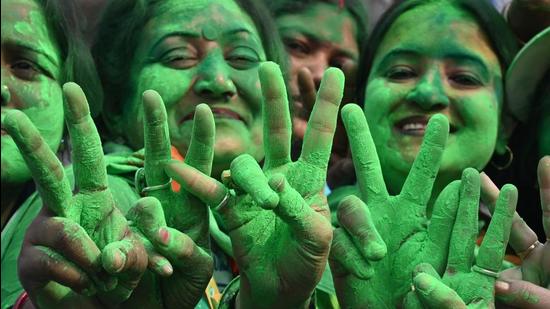 Supporters of the Trinamool Congress (TMC) celebrate the party's victory in the Kolkata Municipal Corporation (KMC) elections, near the residence of the West Bengal chief minister and TMC leader Mamata Banerjee, in Kolkata on December 21, 2021. (AFP) Supporters of the Trinamool Congress (TMC) celebrate the party's victory in the Kolkata Municipal Corporation (KMC) elections, near the residence of the West Bengal chief minister and TMC leader Mamata Banerjee, in Kolkata on December 21, 2021. (AFP)
