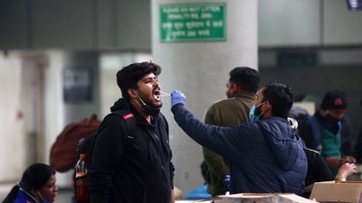 A healthcare worker collects a swab sample of a passenger at Kashmere Gate ISBT amid a surge in Omicron cases, in Delhi on Tuesday. (ANI Photo) A healthcare worker collects a swab sample of a passenger at Kashmere Gate ISBT amid a surge in Omicron cases, in Delhi on Tuesday. (ANI Photo)