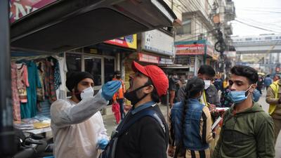 A health worker collects a swab sample for Covid-19 test, at Patel Nagar, on Tuesday. (Sanchit Khanna/HT)