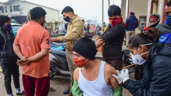 A man receives a dose of the Covid-19 vaccine at a market in New Delhi on Tuesday. The restrictions have been imposed in the national capital due to rising number of Covid cases. (PTI Photo)