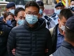 Stand News chief editor Patrick Lam is brought to the news outlet's office building in handcuffs after police were deployed to search the premises in Hong Kong's Kwun Tong district.(AFP Photo) Stand News chief editor Patrick Lam is brought to the news outlet's office building in handcuffs after police were deployed to search the premises in Hong Kong's Kwun Tong district.(AFP Photo)