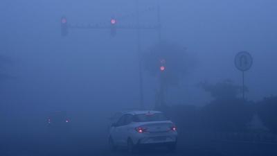 Vehicles halt at a traffic light amid poor visibility due to dense fog, in Dwarka, New Delhi on Tuesday. (Vipin Kumar/HT PHOTO)